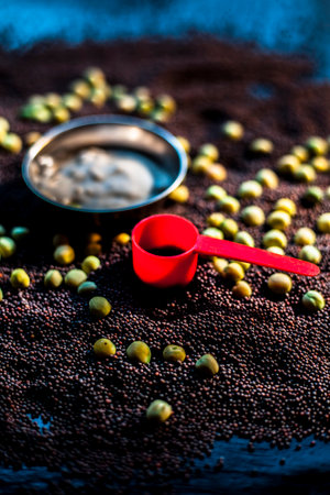 Skin booster in a bowl along with green peas, mustard seeds and some yogurt on black surface.の写真素材