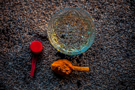 DIY Face mask for smooth and glowing skin. Shot of cumin seeds along with some turmeric on a brown surface making a glowing skin face mask all together.の写真素材