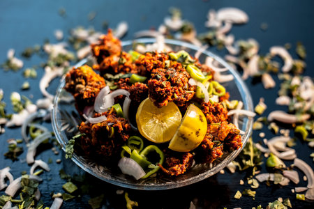 Indian styled meatballs or kabab or kebab on glass plate along with sprinkled cut green chilies and onion rings plus lemon.の写真素材