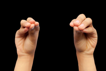pair of male hands doing Mukula Mudra isolated on a black background.の写真素材