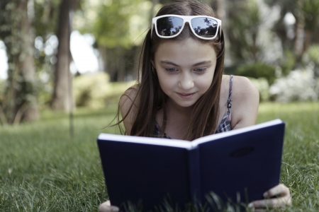  Girl reads book on grassの写真素材