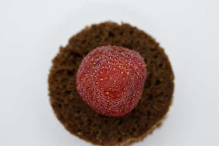 Strawberry on a chocolate muffin isolated on a white backgroundの写真素材