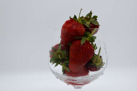 Strawberries in a glass vase on a white background.の写真素材