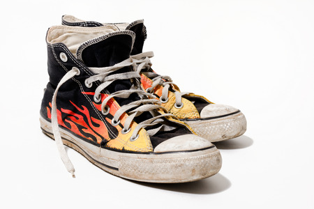 Worn and dirty sneakers isolated on white backgroundの写真素材