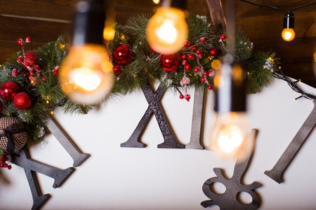 Beautiful holiday decorated living room with Christmas tree and presents. Big magical clock on wooden wall. Winter holidays design and decorations background.の写真素材