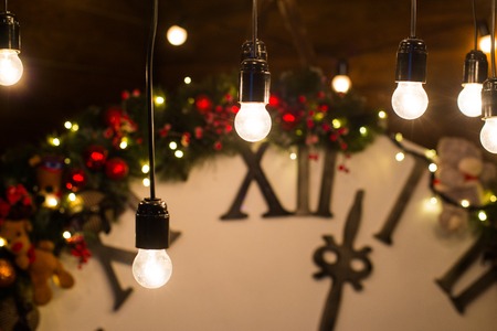 Beautiful holiday decorated living room with Christmas tree and presents. Big magical clock on wooden wall. Winter holidays design and decorations background.の写真素材