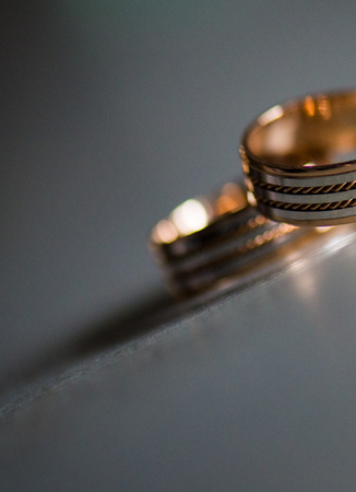 A woman's diamond wedding ring as seen through a man's gold band