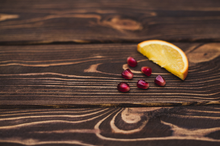 Orange and pomegranate slices on a dark wooden background. Place for your textの写真素材