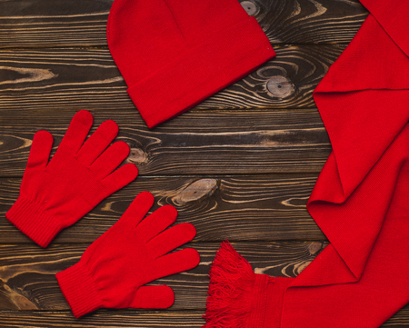 Red gloves, hat, scarf on a wooden backgroundの写真素材