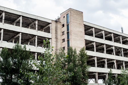Ruined and abandoned demolished building, several storey house, without roof, broken windows and shattered brick wall facadeの写真素材