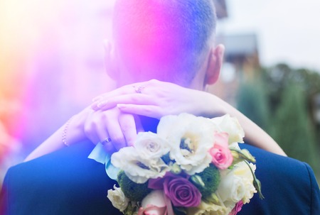 Bride's bouquet behind the groom's back, the bride's napeの写真素材