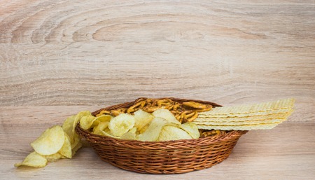 Chips and cracker on a wooden background. Plate with chips.の写真素材