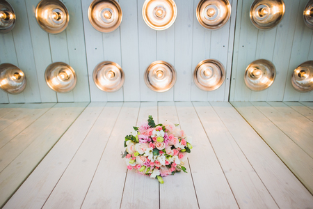 A luxurious wedding bouquet, with fresh roses in studio decorations, amid a series of light bulbs. Place for your text.の写真素材