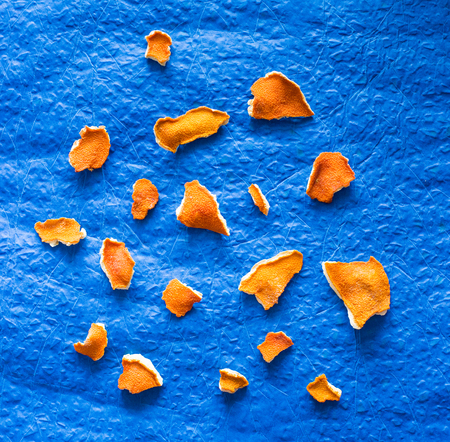 Dried orange peel on a blue background. View from above.の写真素材