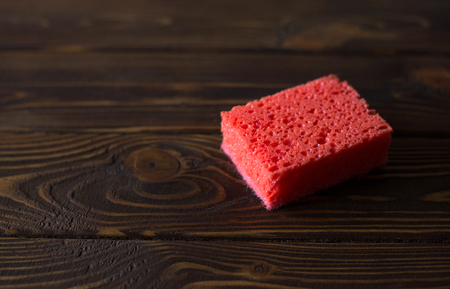 red sponge for washing on a wooden backgroundの写真素材