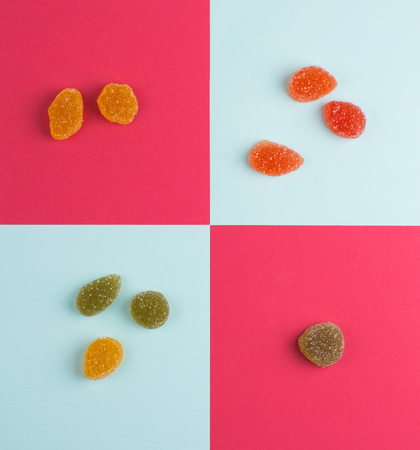 The world of orange marmalade with sugar on a red, blue background. Candy marmalade on a light background. Sweet sweets in sugarの写真素材