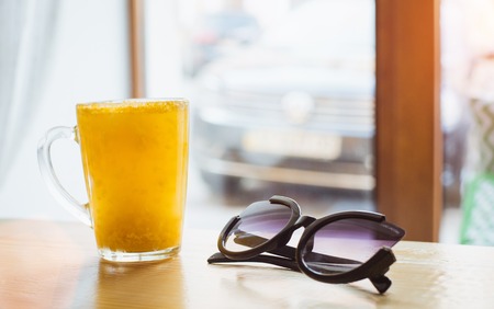 Tea with sea-buckthorn and orange on the background of a cafe and sunglasses