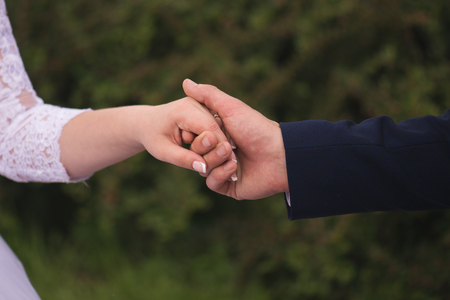 Bride and groom holding hands outdoorsの写真素材