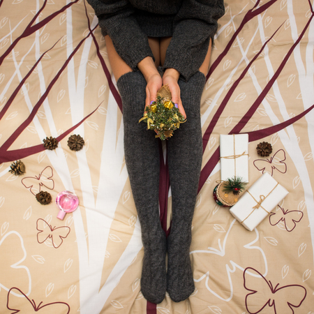 top view of legs in socks, woman sitting on the bed in the morning, cozy, comfortable at home, happy mood, details of the legs, stylish sheets, sexualityの写真素材
