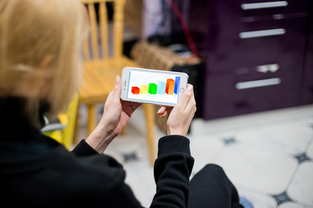 The girl on the smartphone looks graphics. Concepts of digital technologies in everyday life.