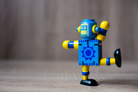 robot toy standing on wooden floorの写真素材