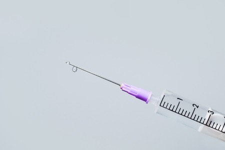 Hypodermic needle ejecting clear liquid - isolated syringeの写真素材