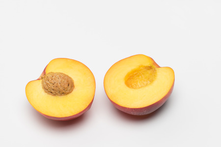 Nectarine cut in half over white backgroundの写真素材