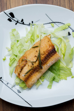 Salmon fillets served on a plate with mixed saladの写真素材