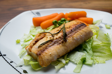 Salmon fillets served on a plate with mixed saladの写真素材