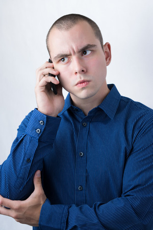 Business man making a call with serious face expressionの写真素材