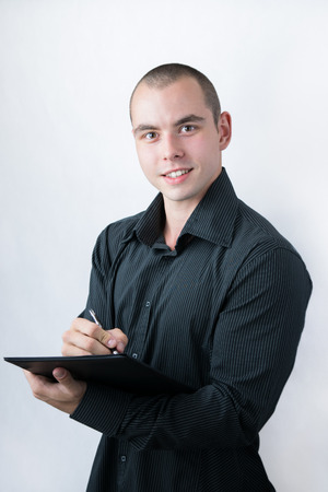 Man holding stack of papers and writingの写真素材