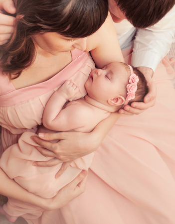 caring loving parents holding cute sleeping little baby girl family relationshipの写真素材