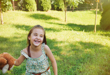 happy smiling little girl playing running outside in summer sunny dayの写真素材