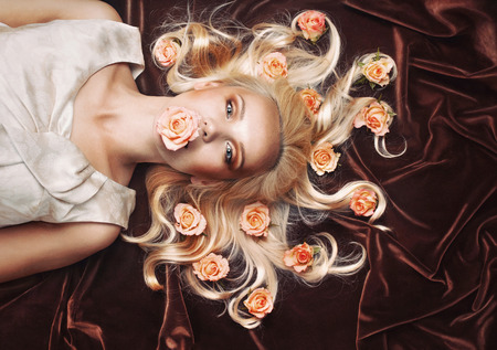 sensual tender woman portrait with magnificent gaze and peachy roses on chocolate background in studioの写真素材