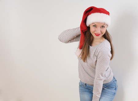 beautiful young woman in santa hat for Christmas or New Year holiday on white backgroundの写真素材