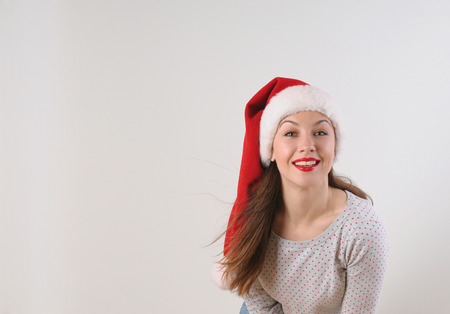 beautiful young woman in santa hat for Christmas or New Year holiday on white backgroundの写真素材