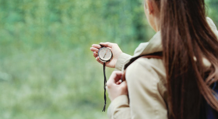 young woman discovering nature in the forest environment with compass, travel lifestyle conceptの写真素材