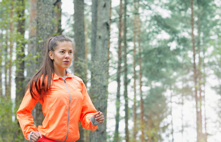 healthy lifestyle fitness sporty woman running early in the morning in forest area, healthy lifestyle conceptの写真素材