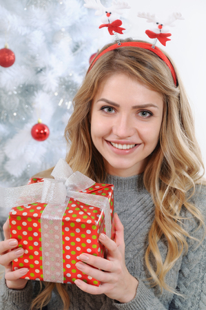 portrait of an attractive young woman with a gift for Christmas, happy holiday conceptの写真素材