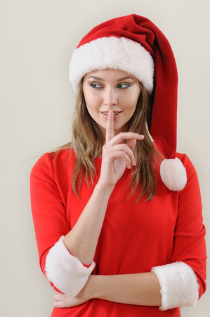 modesty girl weared in santa showing the silence sing. Christmas and New Year conceptの写真素材
