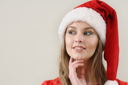 cute young woman in Santa hat make a wish about Christmas gifts.の写真素材