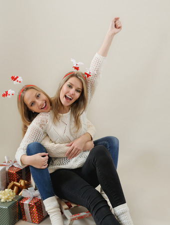 Two happy and funny woman on old sled. Christmas and New Year concept.の写真素材