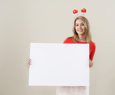 Happy girl in santa claus clothes hold empty blank banner with copy space.の写真素材
