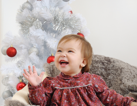portrait of the cute little baby girl before Christmas tree. Christmas and New Year conceptの写真素材
