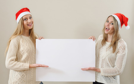 Tho happy girl in santa claus clothes hold empty blank banner.の写真素材