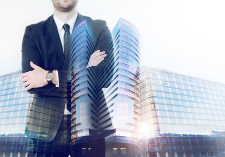 double exposure of business biuldings and business man folded his arms; business conceptの写真素材