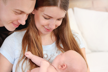 family portrait of little cute baby and parents, happy family conceptの写真素材