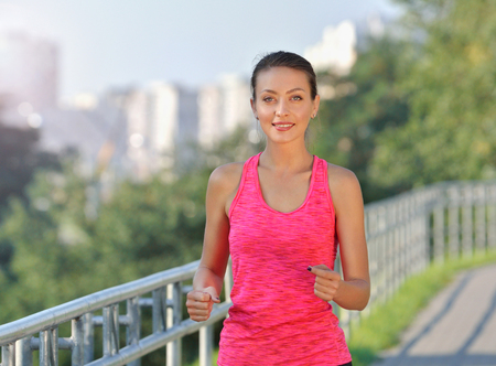 Fitness woman running. Woman jogging on urban road. Fitness girl training outdoorの写真素材