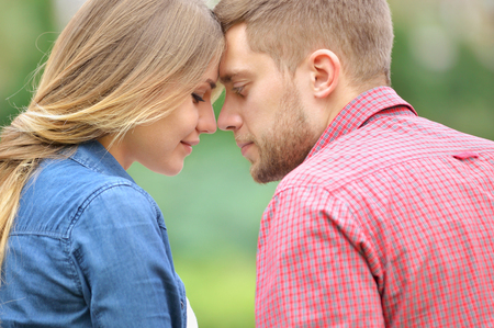 Tender couple in love outdoor. They are smiling and looking at each other.の写真素材