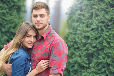 Portrait of happy embracing couple in park. Love, relationship, family and people concept - smiling couple hugging in parkの写真素材